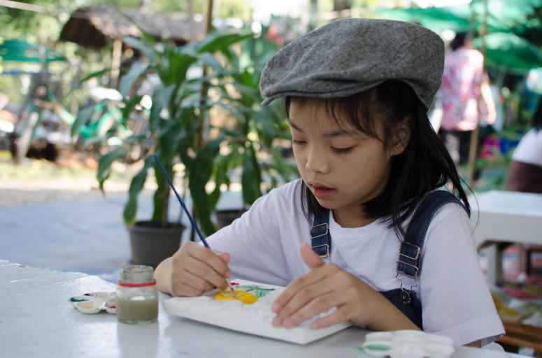 girl holding painting brush on white board